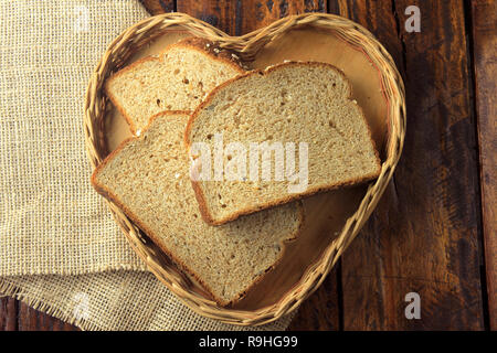 Organici di fette di pane integrale, fatto di avena e semi di lino forma interna cuore cestello. Dieta sana. Vista superiore Foto Stock