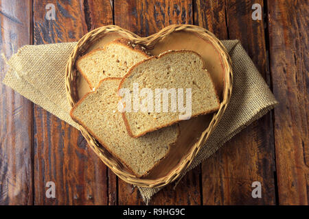 Organici di fette di pane integrale, fatto di avena e semi di lino forma interna cuore cestello. Dieta sana. Vista superiore Foto Stock