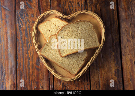 Organici di fette di pane integrale, fatto di avena e semi di lino forma interna cuore cestello. Dieta sana. Vista superiore Foto Stock