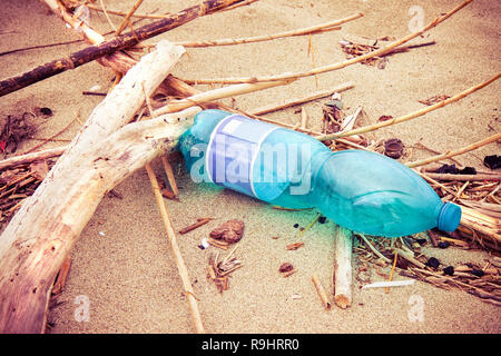 Vuoto in plastica verde bottiglia abbandonati sulla spiaggia - plastica problema dei rifiuti Foto Stock