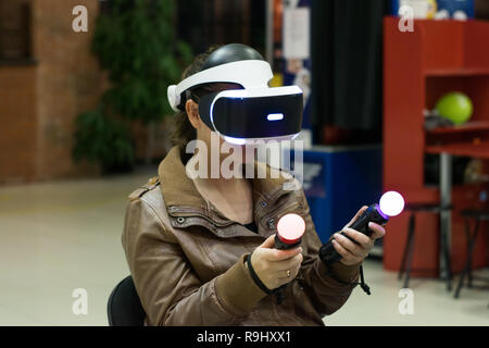 Ragazza in cuffia VR che godendo di gioco. La realtà virtuale. teen in VR auricolare con joystick Foto Stock