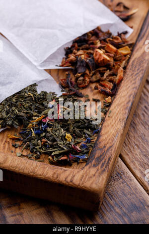 Il tè pacchetti specializzati per la produzione di birra su una tavola di legno. Il tè di diverse varietà. Frutta e tè alle erbe. Varietà di sapori. Foto Stock