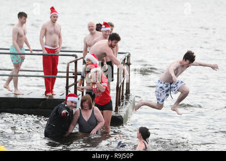 Le persone prendono parte al Clontarf Yacht e Barche annuale del club di nuoto di Natale in aiuto della RNLI. Foto Stock