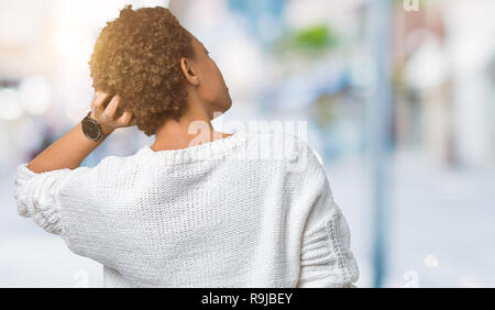 Bella giovane americano africano donna che indossa un maglione su sfondo isolato indietro pensando di dubbio con la mano sulla testa Foto Stock