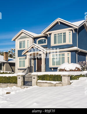 Un perfetto nighborhood. Grande lusso casa residenziale nella stagione invernale. North American Family House su inverno giornata di sole Foto Stock