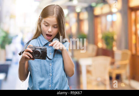 Giovane bella ragazza per scattare delle foto utilizzando la fotocamera vintage su sfondo isolato molto felice puntando con mani e dita Foto Stock