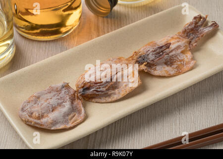 Giapponese essiccato e cotto alla griglia condito squid snack su un piatto di portata Foto Stock