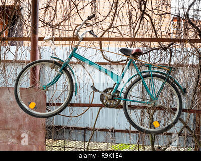 Vecchia bicicletta si blocca sul recinto del capannone rustico nella stagione invernale Foto Stock