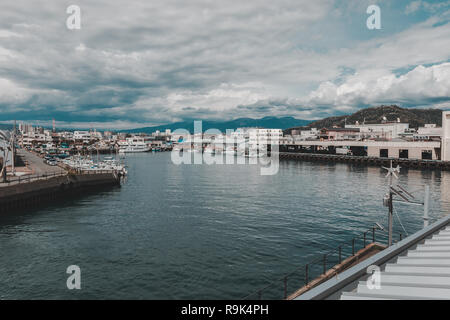 Paesaggio del Porto di Numazu Mercato del Pesce distretto con città di Numazu in background su un giorno nuvoloso Foto Stock