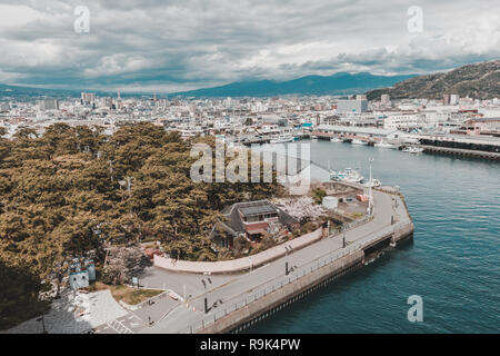 Angolo di alta vista del porto di Numazu Mercato del Pesce distretto con città di Numazu in background su un giorno nuvoloso Foto Stock