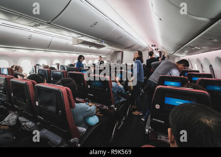 Chiba, Giappone - 16 Aprile 2017: all'interno della cabina della Japan Airlines Boeing 787-900. Il passeggero sono memorizzare i loro bagagli e appartenenti prima del decollo Foto Stock