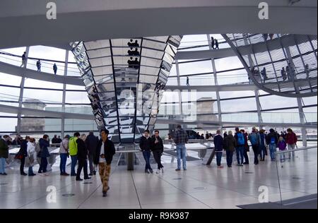 Vista interna di visitatori sul pavimento in corrispondenza della base del cono di mirroring e sulla passerella all'interno della cupola di vetro sul tetto dell'Edificio del Reichstag Foto Stock