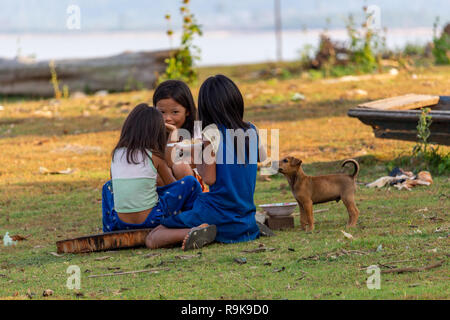 Thakhek, Laos - 19 Aprile 2018: bambini locali giocare a mangiare un pasto che hanno fatto con il fango come un gioco in una zona rurale remota del Laos Foto Stock