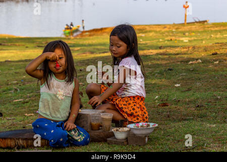 Thakhek, Laos - 19 Aprile 2018: bambini locali giocare a mangiare un pasto che hanno fatto con il fango come un gioco in una zona rurale remota del Laos Foto Stock