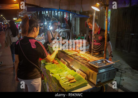 NAKHON PHNOM, Tailandia - 19 OTT 2018 : merchant vendere Isan salsiccia grigliare sul fornello a Nakhonphanom walking street market Foto Stock