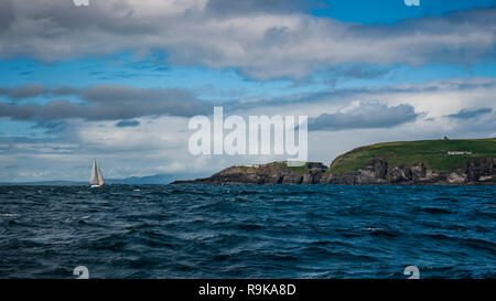 Lonely vela barca si avvicina terra dopo la tempesta. Mizen Head. Angolo sud-occidentale dell'Irlanda. Foto Stock