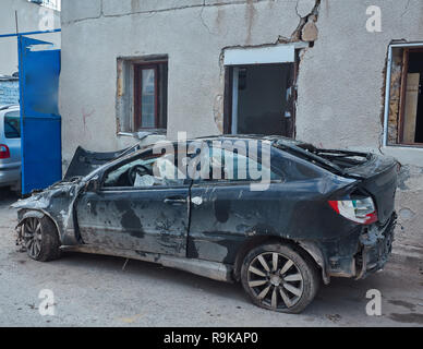 Si è schiantato, distrutto e bruciato auto abbandonate a sinistra accanto al lato di un vicolo del paese. Foto Stock