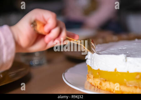 Bambino a rubare un pezzo di torta di raggiungere con la forca nel dolce con nessuno Foto Stock