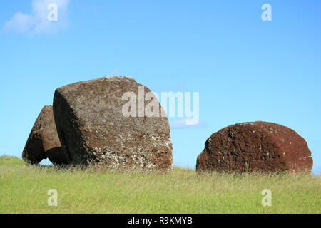 Abbandonato il moai scolpito statue' copricapo chiamato Pukao di Puna Pau vulcano, il rosso le scorie di Cava sito archeologico sull'Isola di Pasqua, Cile Foto Stock