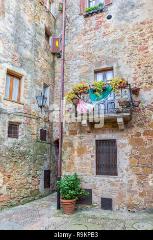 L'italiano nel cortile con un balcone con fiori Foto Stock