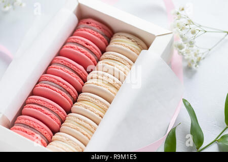 Corallo e torte beige macarons o amaretti in una scatola regalo bianca. Il concetto di giorno di San Valentino e la molla è in festa. Foto Stock