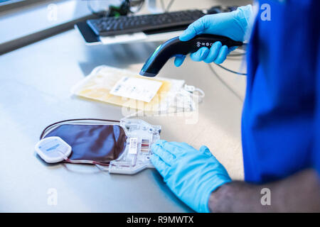 Hagen, Germania. 03 Dic, 2018. Un DRK-West dipendente effettua una scansione di una sacca di sangue in stabilimento di produzione di prodotti a base di sangue. Come la più grande banca del sangue in Europa, la creazione della DRK-ovest in Hagen è nuovo per l'inizio e serve molte cliniche e migliaia di pazienti in diversi stati federali. (A DPA-KORR: 'più grande banca del sangue in Europa: frigorifero completo anche per situazioni di crisi" del 27.12.2018) Credito: Marcel Kusch/dpa/Alamy Live News Foto Stock