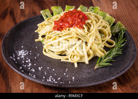 Pasta spaghetti con zucchini, basilico, panna e formaggio su un tavolo di legno. Vegetariano pasta vegetale. Tagliatelle di zucchine. Foto Stock