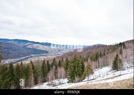 Snowy mountain valleys at Carpathian mountains. View of Ukrainian Carpathians and Yaremche from the top of Makovitsa. Foto Stock