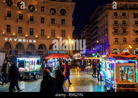 Greek street produttore presso Piazza Aristotelous, Salonicco. Vista serale della folla e illuminati rimorchio vendita caramella di cotone, castagne o pop-corn. Foto Stock