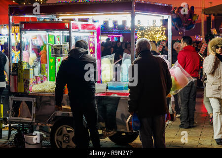 Greek street produttore presso Piazza Aristotelous, Salonicco. Vista serale della folla e illuminati rimorchio vendita caramella di cotone, castagne o pop-corn. Foto Stock