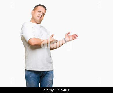 La mezza età uomo arabo wearig t-shirt bianco su sfondo isolato invitante per immettere sorridente naturale con mano aperta Foto Stock