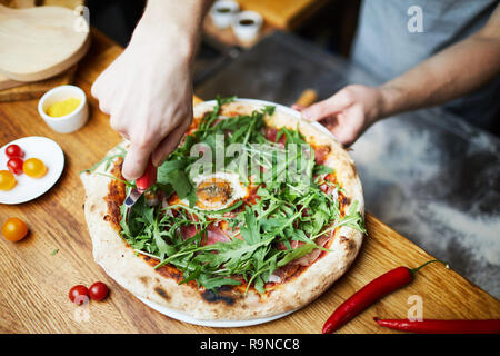 Pizza di taglio prima di servire Foto Stock