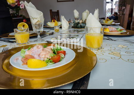 Antipasti di cocktail di gamberi e melone lungo con bicchieri di succo di arancia su una tavola di design pronto per mangiare un pasto. Foto Stock