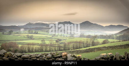 Il cielo era abbastanza drammatico di questa mattina con il cloud ribaltamento Walna Scar mentre nebbia bassa appeso sopra Coniston Water di seguito. Ho preso questo colpo alla ricerca Foto Stock