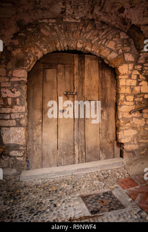 Vecchia porta di legno del medio evo. Molto vecchio muro di pietra. Foto Stock