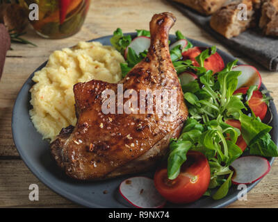 Succosa anatra arrosto gamba con pomodoro, erbe ,purè di patate in una piastra Foto Stock