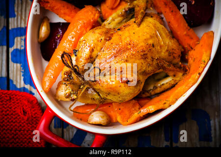 Il pollo cotto con raccolti di radice. vista dall'alto. messa a fuoco selettiva. Foto Stock