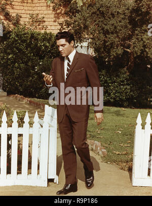 Elvis Presley, indossa una tuta marrone e camminare da un Picket Fence, circa 1964 Riferimento File # 33635 714THA Foto Stock