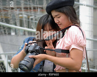 Due ragazze Thai controllare il loro ritratto foto sullo schermo LCD di un Canon EOS 750D fotocamera reflex digitale. Foto Stock
