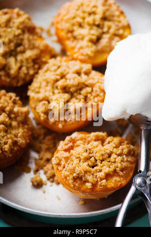 Il forno di pesche con una briciola di pane speziato e gelati. stile vintage. messa a fuoco selettiva Foto Stock