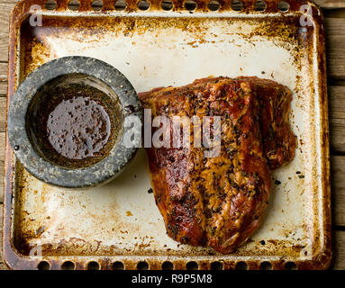 Pezzo di carne di maiale grezzo pronto per la tostatura su una placca da forno. vista dall'alto. messa a fuoco selettiva. stile vintage Foto Stock