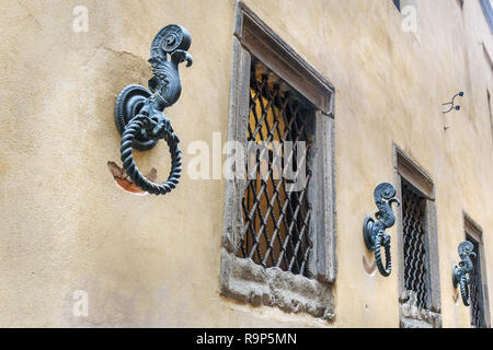 Antica anelli di ferro per legare i cavalli sulla parete nella vecchia città di Siena. Italia Foto Stock