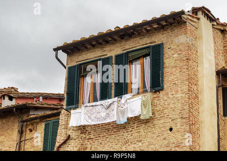 Tradizionale di windows con persiane di legno della vecchia casa in Siena. Italia Foto Stock