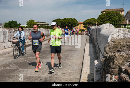 Guide a dieci miglia a correre attraversando il Ponte di Tiberio (Ponte di Tiberio), AD 21, ponte romano a Rimini, Emilia Romagna, Italia Foto Stock