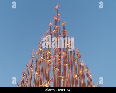 Natale o albero di Natale decorato con stelle di luci di forma contro il cielo blu chiaro Foto Stock