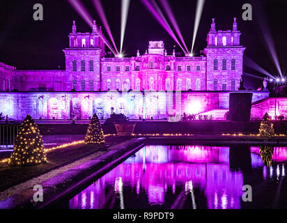 Il Palazzo di Blenheim e acqua terrazza illuminata con le luci di Natale completo con laser show nel cielo notturno. Foto Stock