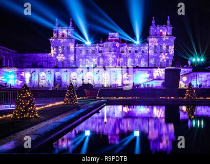 Il Palazzo di Blenheim e acqua terrazza illuminata con le luci di Natale completo con laser show nel cielo notturno. Foto Stock