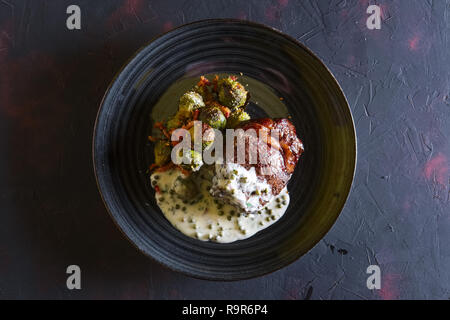 Bistecca di manzo fritto con cavolini di Bruxelles e cremosa salsa di piselli Foto Stock