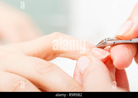 La cura delle unghie, beauty wellness spa il concetto di trattamento. Donna preparazione prima di unghie manicure, il taglio di cuticole utilizzando clippers. Foto Stock