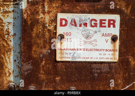 "Ira' Rajasthan Electricity Board segno di avvertimento su una porta arrugginita, Udaipur, Rajasthan, India. Foto Stock